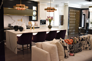 Room image of a couch with a kitchen in behind.