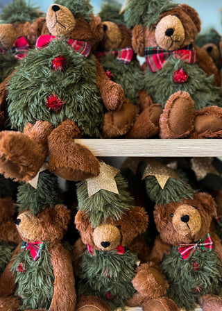 Collection of teddy bears dressed as Christmas trees with green fur, red bows, and holly leaves.