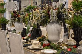 Decorative table setting with vases, flowers, and tableware in a festive arrangement.