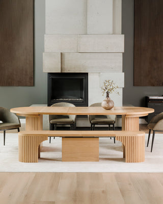 Wooden dining table with chairs in a modern living room setting.